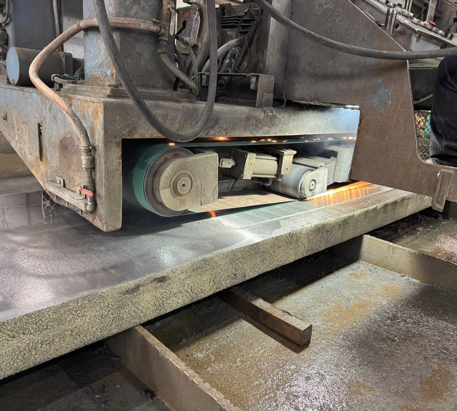 Large circular steel disc being cut by a vertical bandsaw machine