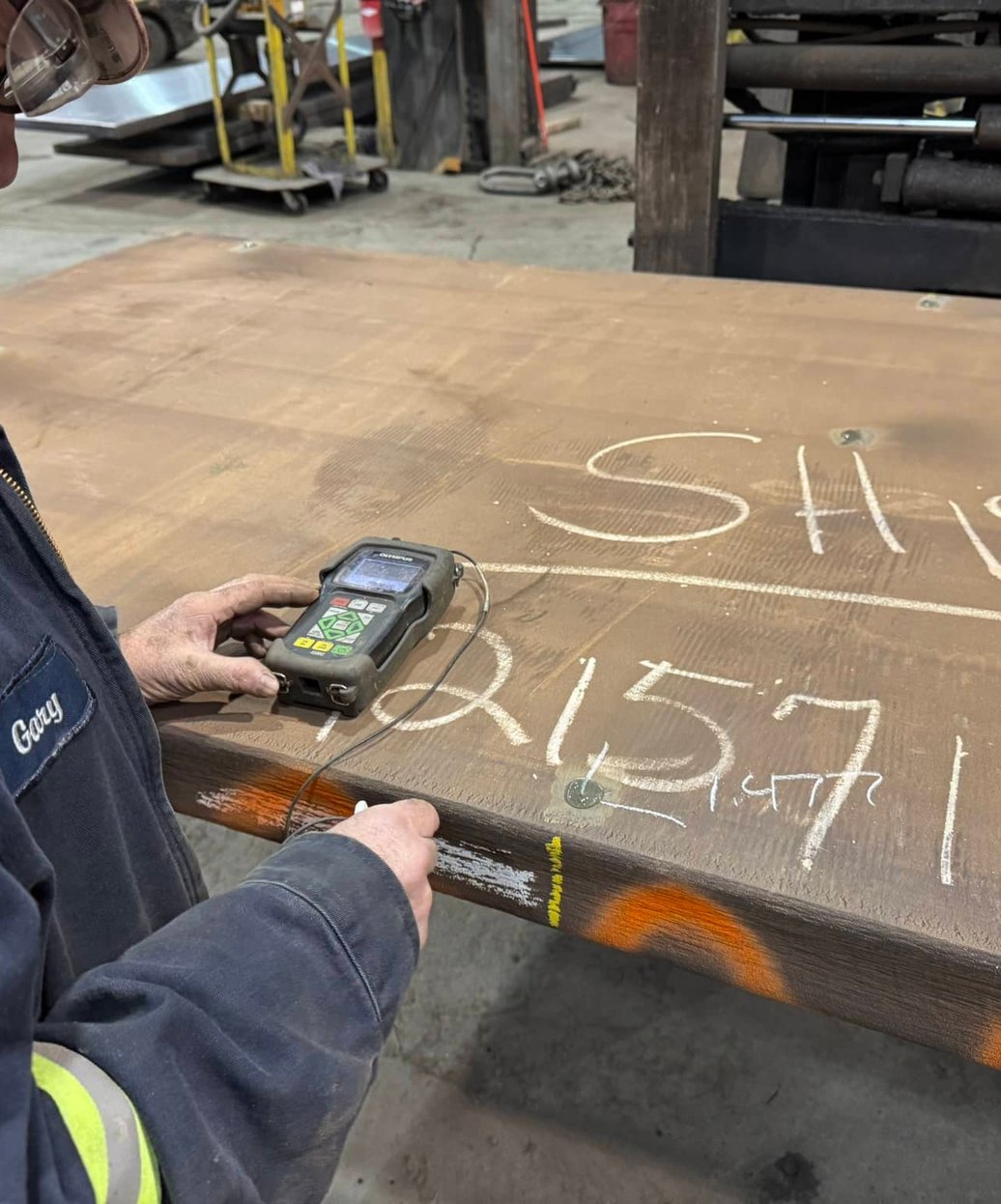 Level II NDT inspector performing ultrasonic testing on specialty alloy plate